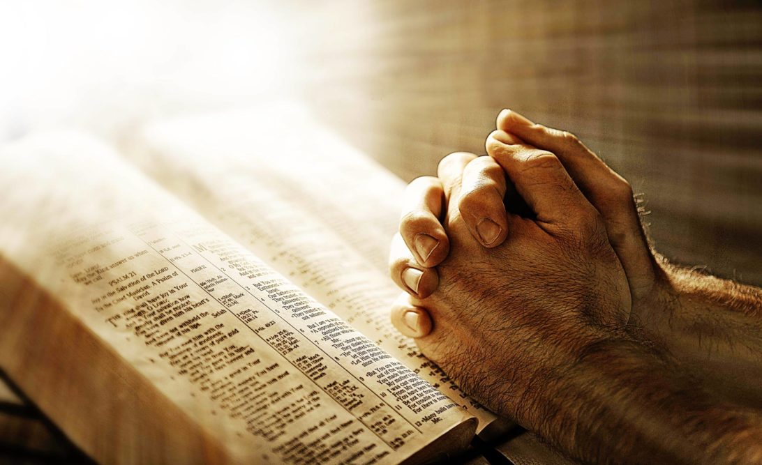 Praying Hands on a Holy Book. A Very Human Phenomena, based in Hopes and Fears, and the feeling of Helplessness. Some Turn to Prayer, others to Magic, and a very few, choose the path of self introspection, self honesty and self transformation through efforts of renunciation of false views and clinging to impermanent things.
